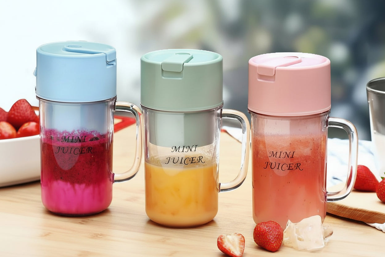 Three mini juicers with colorful lids on a wooden surface with fruits.